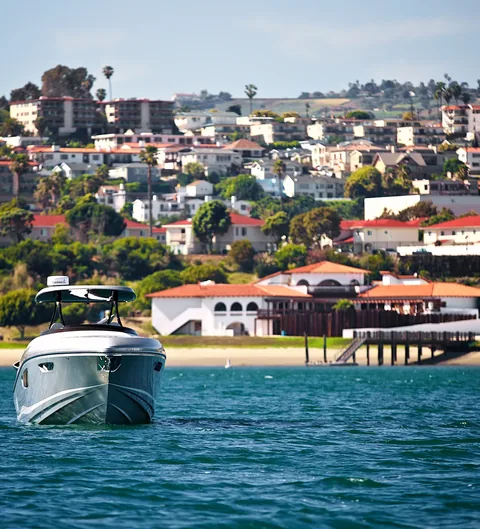 Sport boat running along a hillside coastline