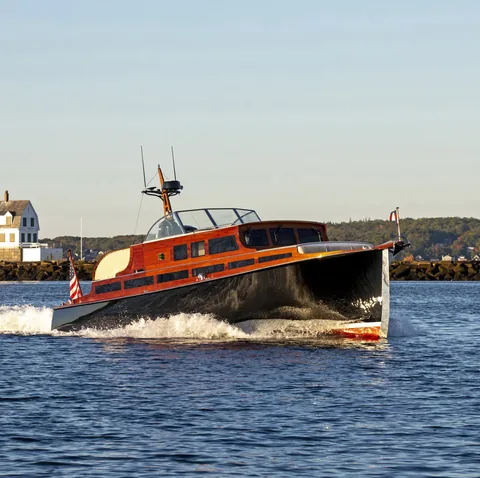 Wooden commuter yacht running, bow quarter